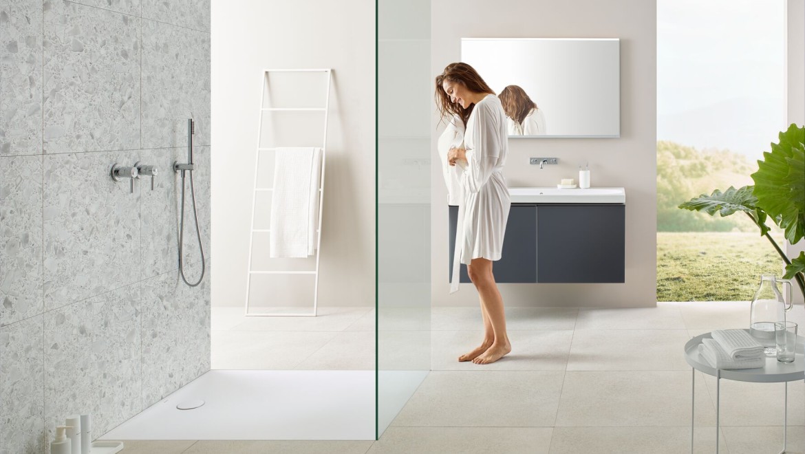 Woman standing in a bathroom with a walk-in shower