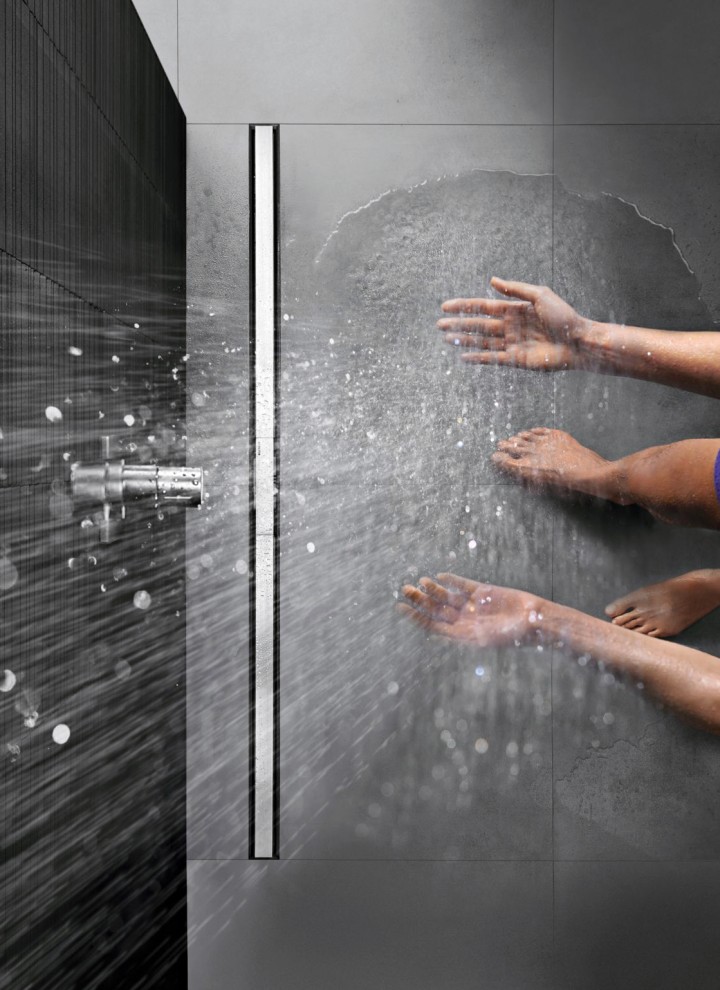 Person showering in a floor-even shower with CleanLine