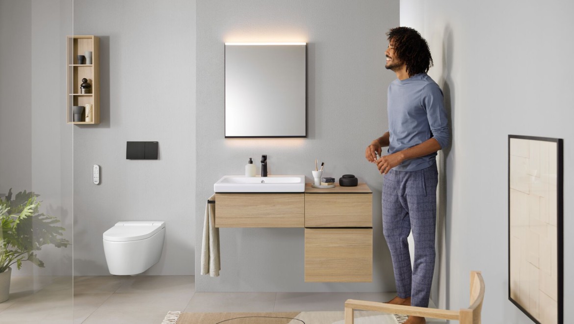 Man standing in the bathroom with an AquaClean Sela shower toilet