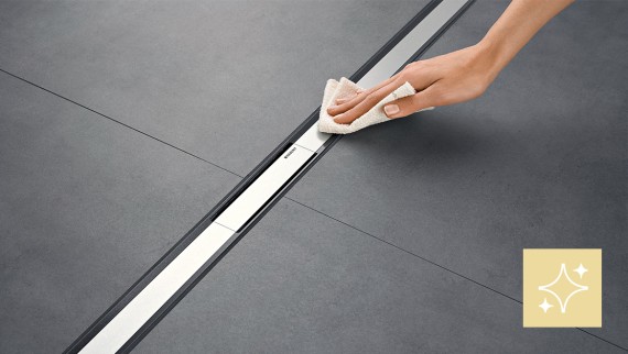 Woman cleaning the Geberit CleanLine shower channel Woman cleaning the Geberit CleanLine shower channel