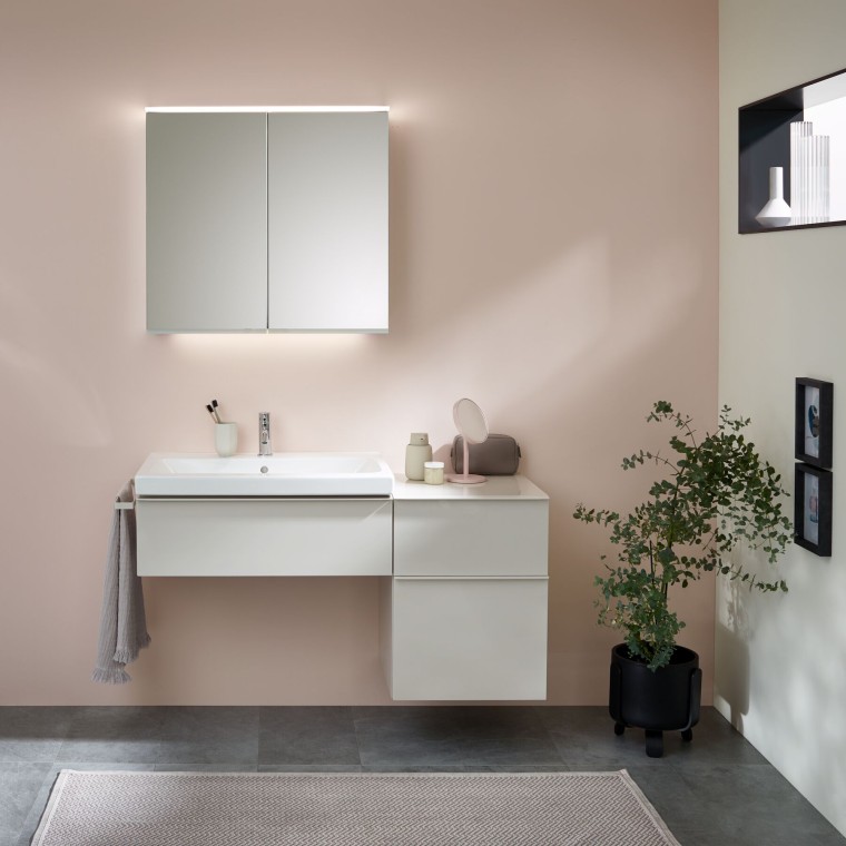 Washplace with bathroom furniture, washbasin and mirror cabinet from Geberit in front of a pastel wall Washplace with bathroom furniture, washbasin and mirror cabinet from Geberit in front of a pastel wall