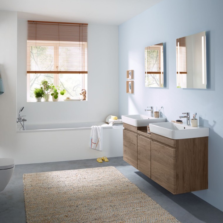 Family bathroom with light-blue wall and bathroom furniture in hickory, mirror cabinet, actuator plate and ceramic appliances from Geberit Family bathroom with light-blue wall and bathroom furniture in hickory, mirror cabinet, actuator plate and ceramic appliances from Geberit