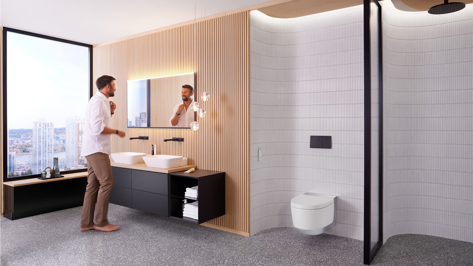 Man in bathroom standing in front of Geberit Option Plus mirror and black Geberit ONE bathroom furniture (© Geberit) Man in bathroom standing in front of Geberit Option Plus mirror and black Geberit ONE bathroom furniture (© Geberit)