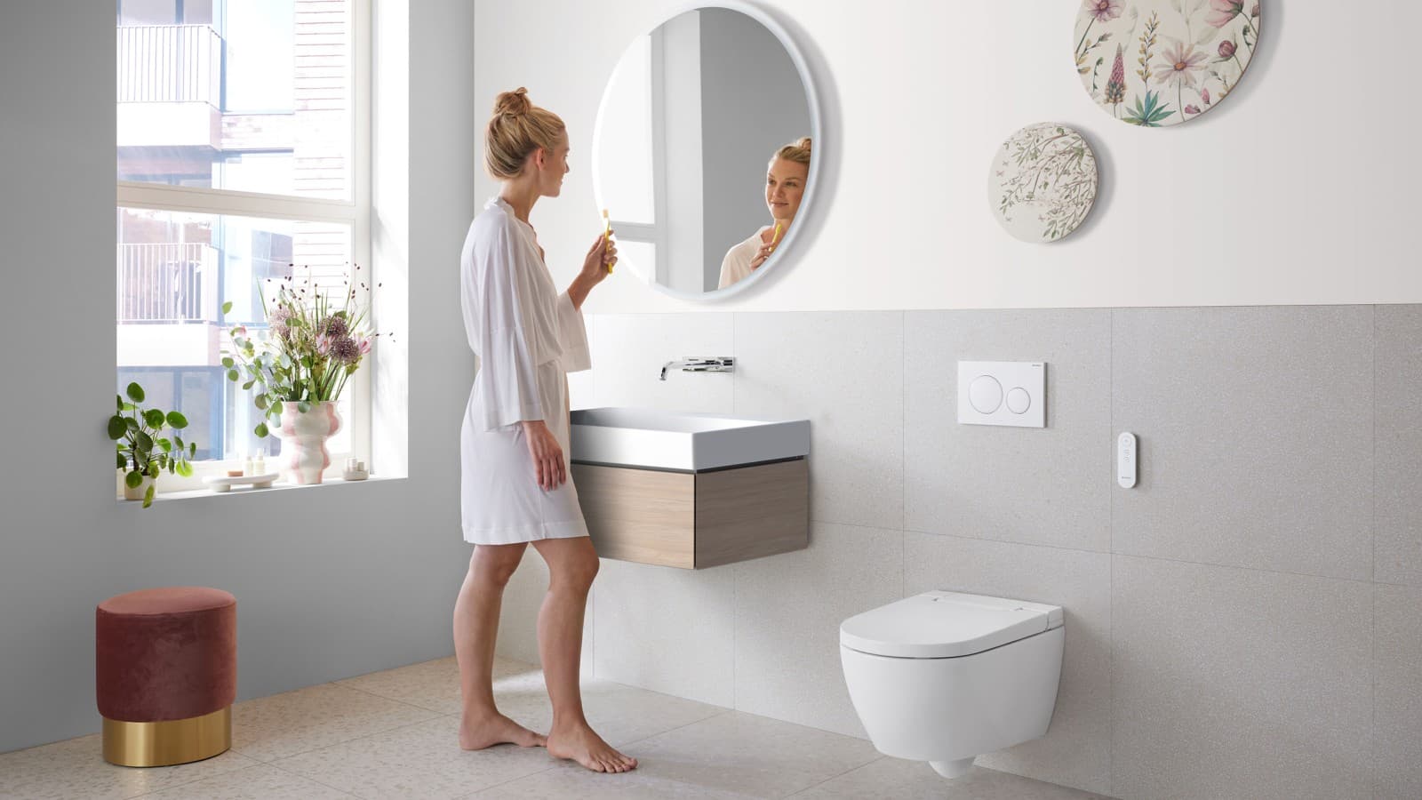 Woman in bathroom with Geberit AquaClean Alba - a cost-effective bidet toilet spray functionality Woman in bathroom with Geberit AquaClean Alba - a cost-effective bidet toilet spray functionality