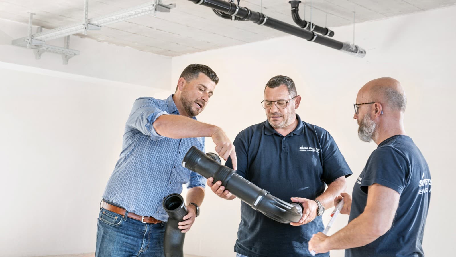 Geberit sales manager Fabian Ritter explains the new Geberit Silent-Pro BottomTurn bend to project manager Marcel Roth and his team Geberit sales manager Fabian Ritter explains the new Geberit Silent-Pro BottomTurn bend to project manager Marcel Roth and his team